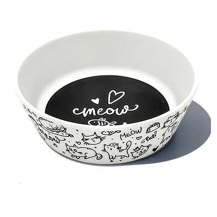 white cat bowl with black  cats and the word meow printed on it, inside a black bottom with a fish and the word meow